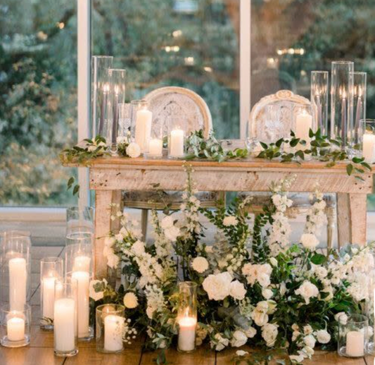 Sweetheart table with a mix of bud vases & floor cylinder of different heights